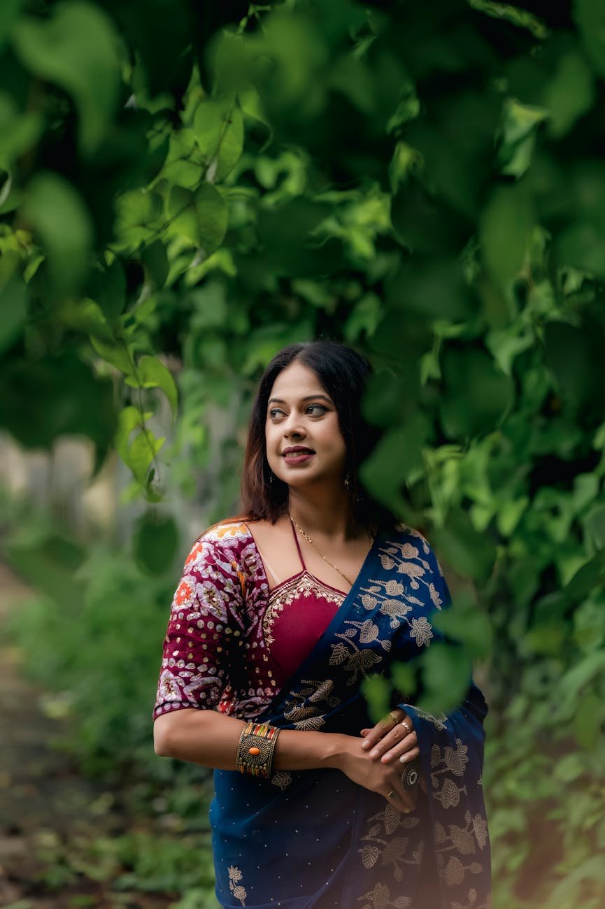 elegant woman in traditional saree in lush greenery
