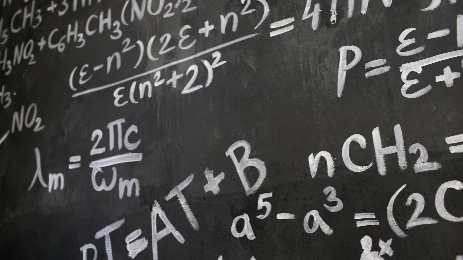 close up of complicated equations written on a blackboard